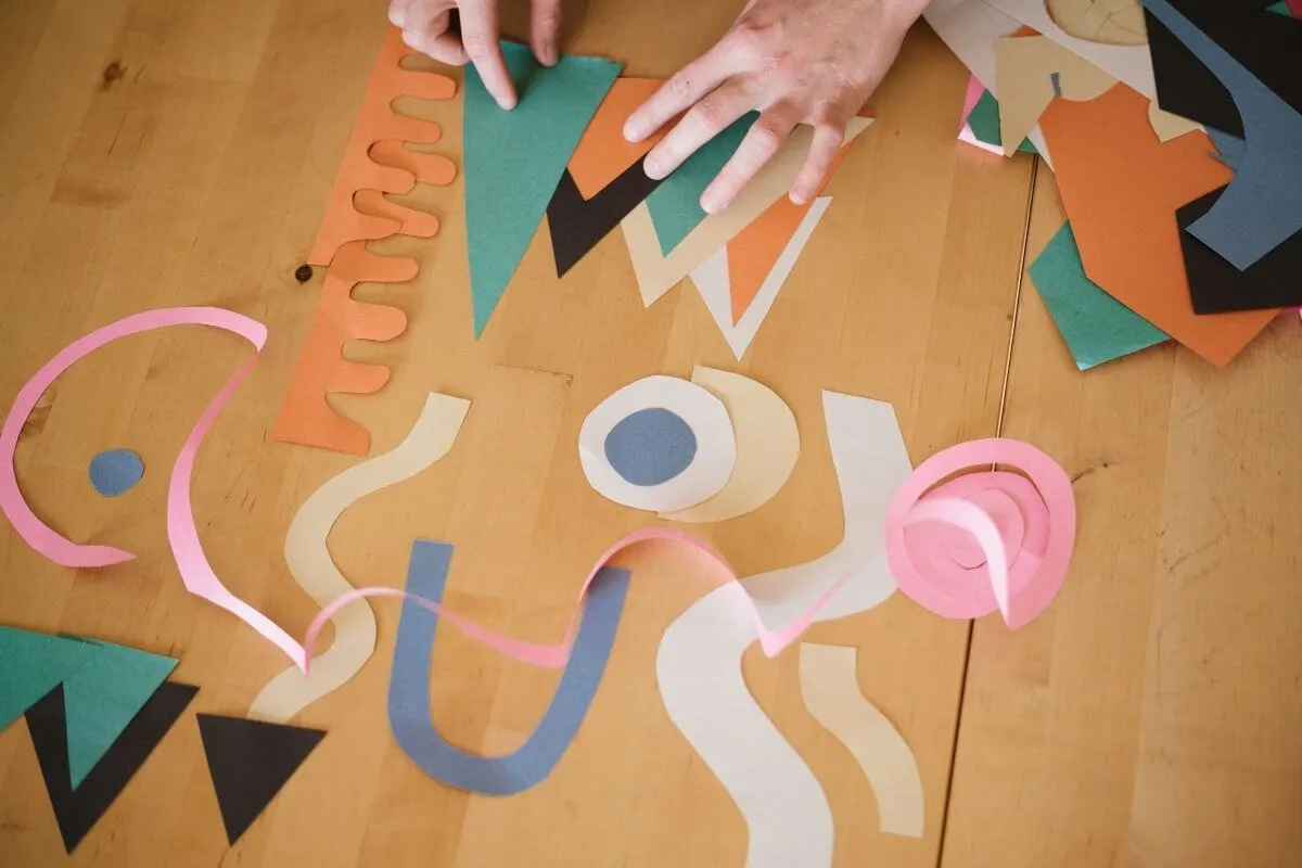 Someone cutting up paper into different shapes