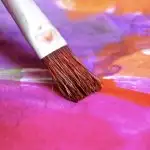 Paint brush with purple, pink and orange water colour