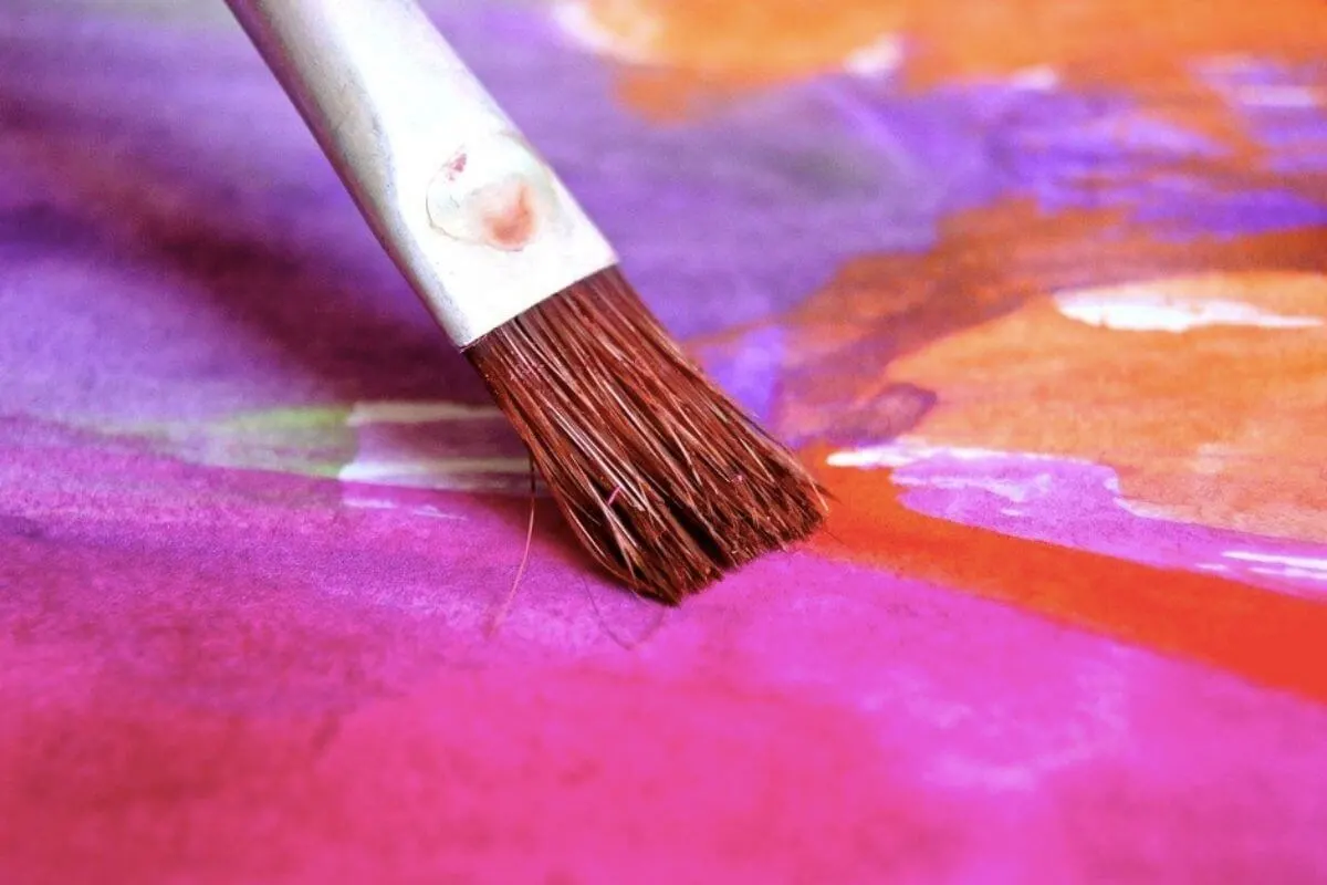 Paint brush with purple, pink and orange water colour
