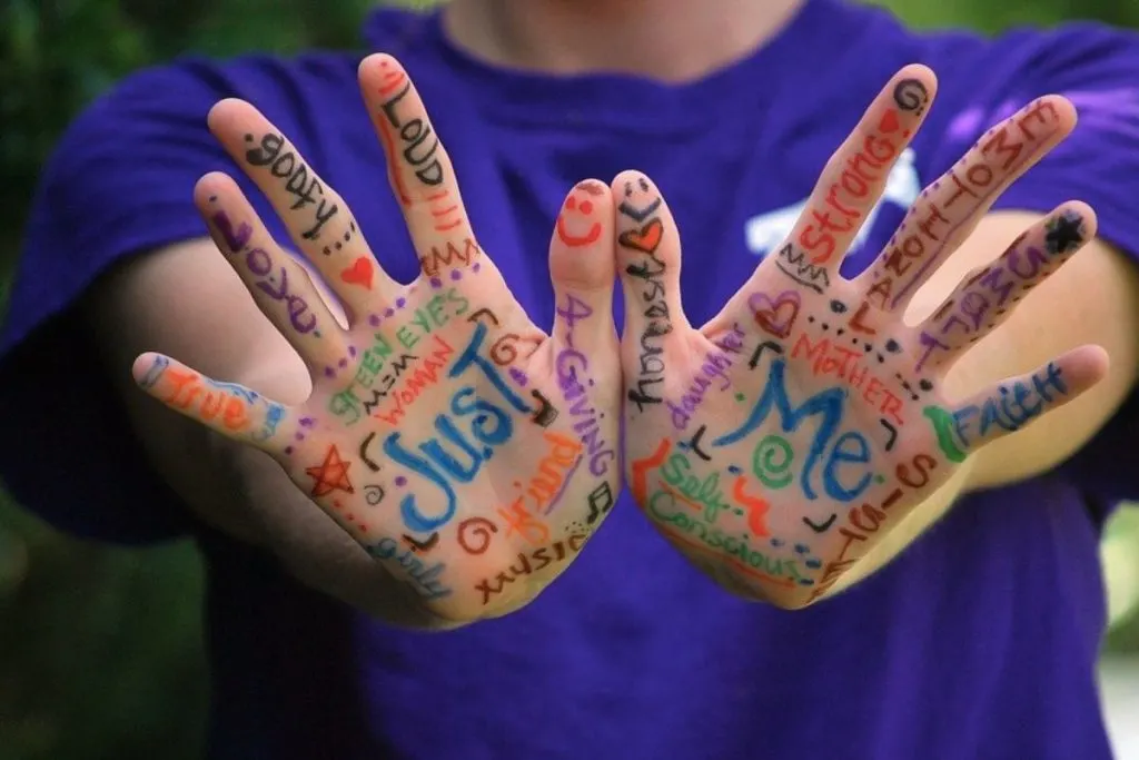 A child holding their hands with paint on